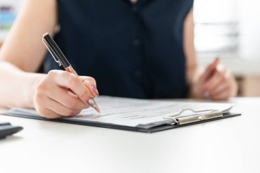 Kadınların elleri hesap makinesine güvenir ve formu doldurur.