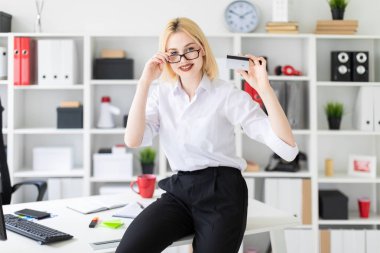 ofiste, genç iş kadını tutar kredi kartı 