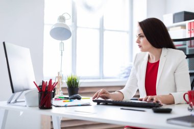 Bilgisayarda parlak ofiste çalışan Office genç kadın 