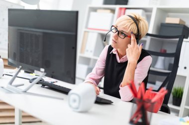 ofiste ve kulaklık ile genç iş kadını 