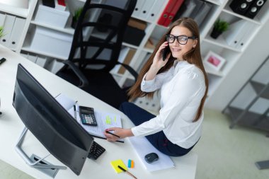 Masada oturan ve ofiste çalışan genç kız