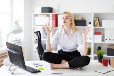 oturma ve ofiste bir tablo üzerinde meditasyon genç iş kadını.