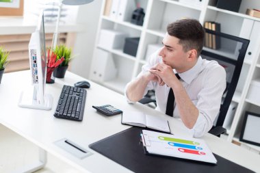 bilgisayarda ofis masasında oturan ve belgelerle çalışma genç işadamı.