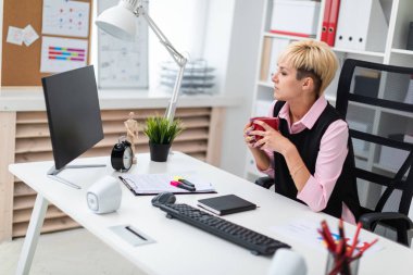 kahve fincanı ile ofiste masada genç iş kadını