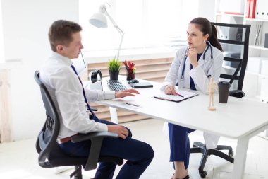 ofiste masada otururken görüşme genç hasta doktor 