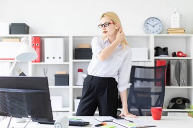 ofiste bilgisayar masasında duran genç iş kadını. 