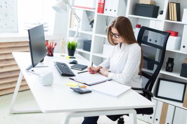 Masada oturan ve ofiste çalışan genç kız