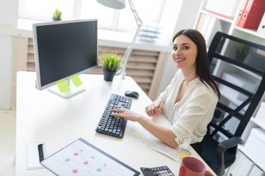 ofiste bir masada çalışan genç iş kadını