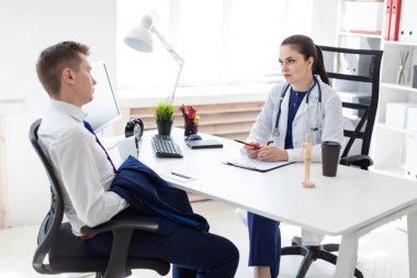 ofiste masada otururken görüşme genç hasta doktor 