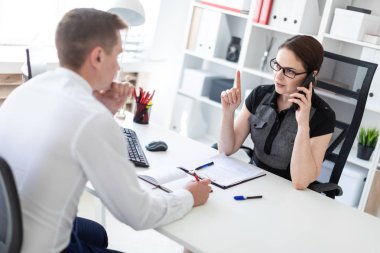 Yatırımcı Smartphone'da meslektaşım ofiste iş toplantısında konuşuyor 