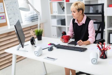 kahve fincanı ile ofiste masada genç iş kadını