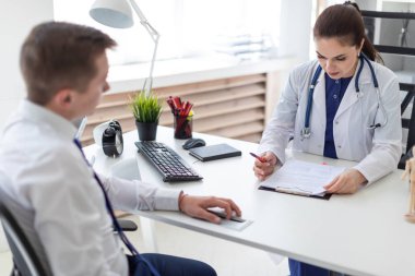 Doktor ofisinde masada erkek hasta tanı açıklama 