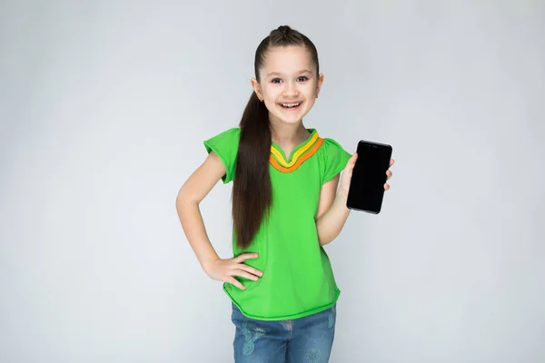 Dívka Šedém Pozadí Dlouhými Vlasy Zelené Tričko Smartphone — Stock fotografie