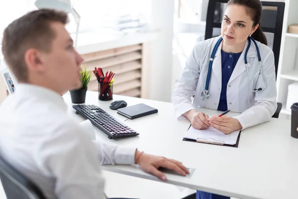 Belo Jovem Médico Jaleco Branco Ouvindo Atentamente Paciente Masculino Escritório — Fotografia de Stock