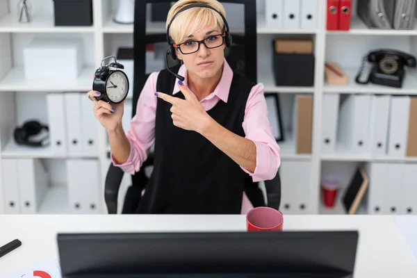 young businesswoman with clock in hand and computer  in the office