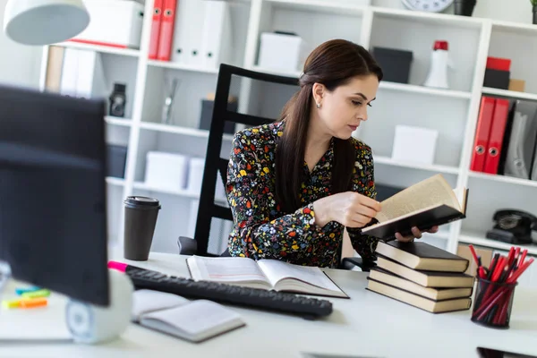 accountant reading business book while sitting at table in bright office 