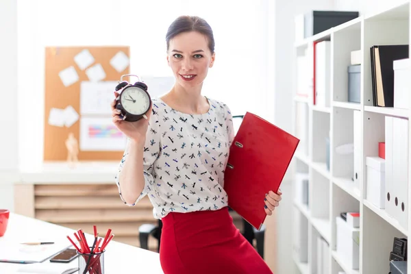 En ung flicka sitter på kontoret på en dator skrivbord och arbeta med dokument och en miniräknare. — Stockfoto