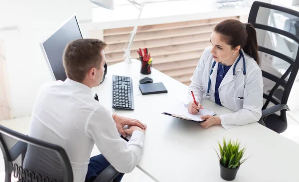 Läkare Förklara Diagnos För Manlig Patient Vid Bord Office — Stockfoto