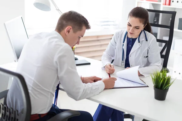 Paciente Assinar Documentos Seguro Saúde Enquanto Sentado Consultório Médico — Fotografia de Stock