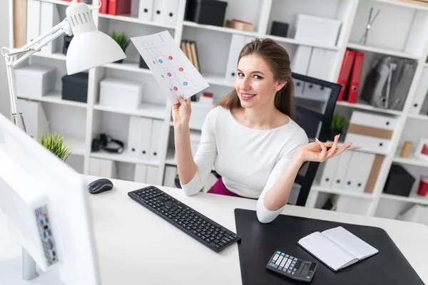 Genç bir kız bilgisayar near Danışma standları ve beyaz bir levha ile bir tablet tutar.