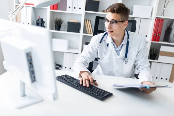 Jovem Médico Trabalhando Computador Enquanto Senta Com Documentos Local Trabalho — Fotografia de Stock