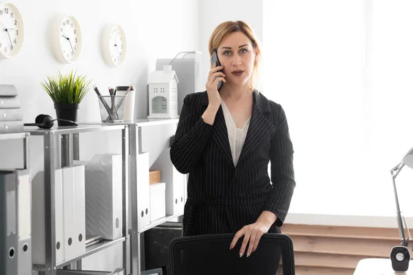 事務所に立って 携帯電話で話している若い実業家 — ストック写真