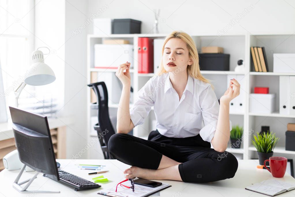young businesswoman sitting and meditating on a table in the office.