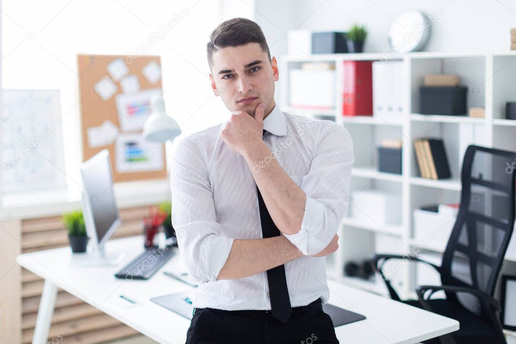  young businessman stands in the office 
