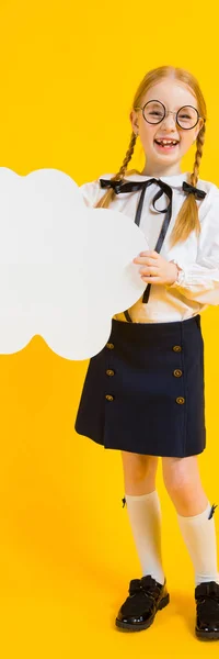 Chica con coletas rojas sobre un fondo amarillo. Una encantadora chica con gafas redondas transparentes sostiene una nube blanca en sus manos . —  Fotos de Stock