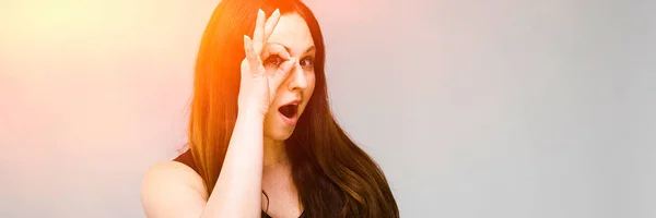 Emotional confident plus size model standing in studio showing ok sign on gray background — Stock Photo, Image