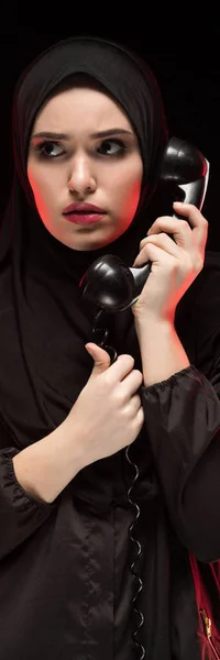 Retrato de una hermosa mujer musulmana asustada y asustada que usa hiyab negro pidiendo ayuda sobre fondo negro — Foto de Stock