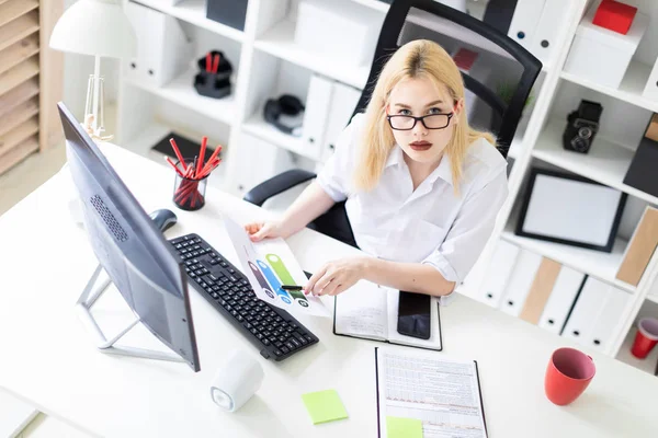 Una joven que trabaja en la oficina con una computadora y documentos . — Foto de Stock