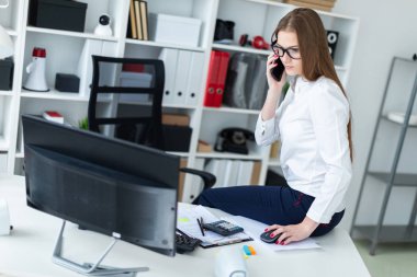 Evet ve bir bilgisayar, belge ve hesap makinesi ile çalışmaya masada, bir genç kız oturdu