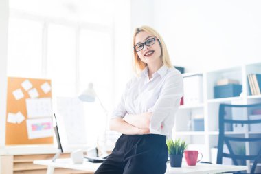 Genç bir kız ofiste masanın üstüne eğildi.