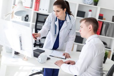 Doktor hastaya bilgisayarda sorunu anlatan.