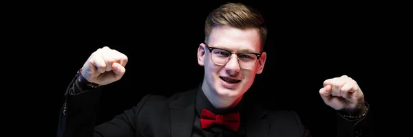 Portrait of confident handsome excited happy elegant responsible businessman showing fists as success concept on black background — Stock Photo, Image