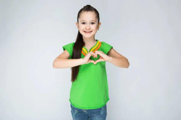 La chica sobre un fondo gris y muestra las palmas del corazón . —  Fotos de Stock