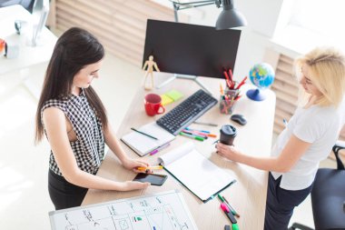 İki kız ofiste çalışmak. Bir telefon tutarak kız.
