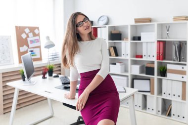 Tablo ve holding gözlük bir genç kız oturdu.