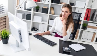 Bilgisayar masasında çalışan bir genç kız.