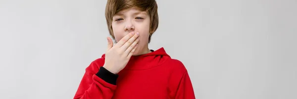 Lindo niño sorprendido caucásico seguro en suéter rojo sobre fondo gris — Foto de Stock