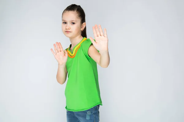 The girl on a gray background stretches her hands forward. — Stock Photo, Image