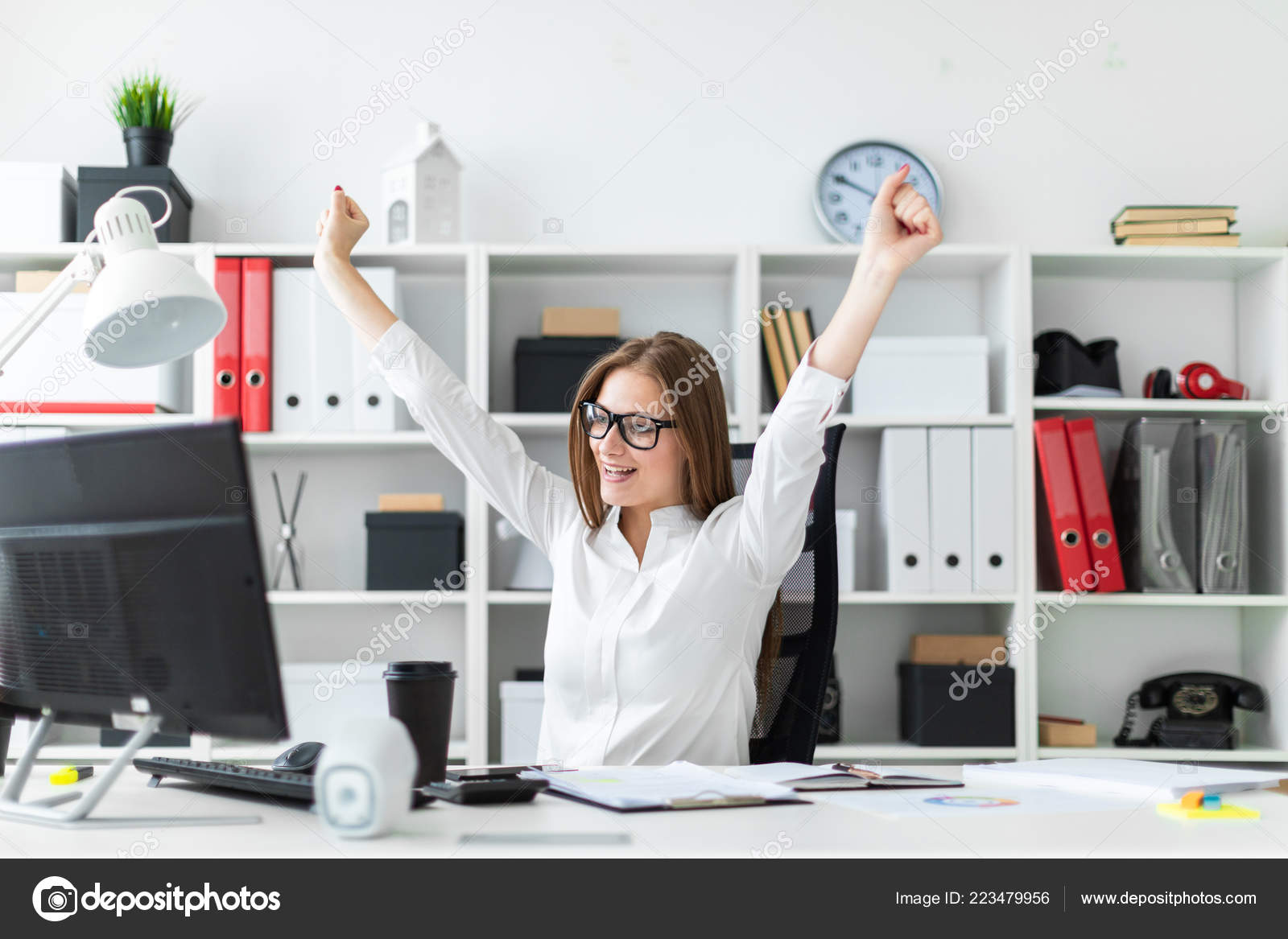 A Young Girl Sitting At A Computer Desk In The Office And Raised