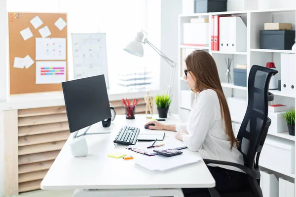 Jong meisje zitten aan de tafel en het werken met een computer, documenten en calculator — Stockfoto