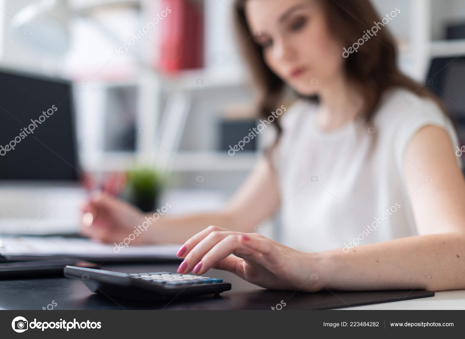 A Young Girl Sitting In The Office At A Computer Desk And Counting