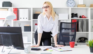 Ofiste bilgisayar masasında duran genç bir kız.