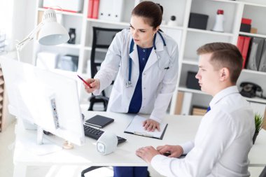 Doktor hastaya bilgisayarda sorunu anlatan.
