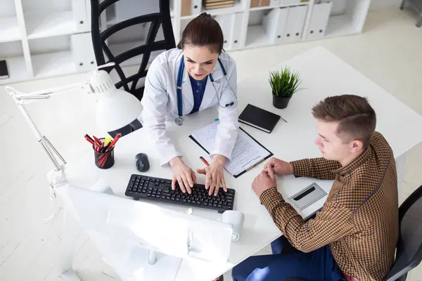 Il medico spiega il problema al paziente sul computer . — Foto Stock