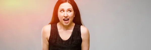 Retrato de emocional bastante confiado desconcertado modelo sorprendido más tamaño de pie en el estudio sobre fondo gris —  Fotos de Stock