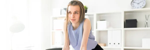 Beautiful young girl in an office stands near leans hands on a table and holds a pink marker. — Stock Photo, Image